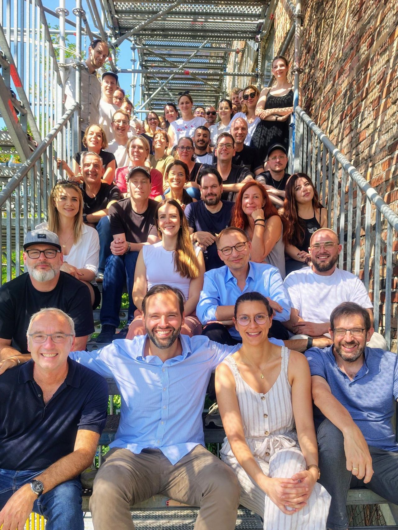 Das Team von MAI mediaworx auf der Außentreppe des Berliner Büros